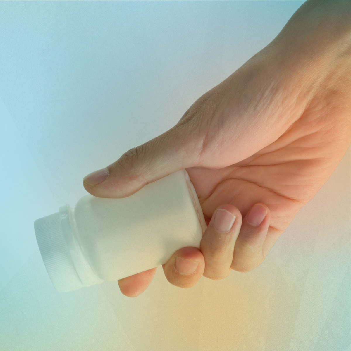 Hand holding pill bottle 